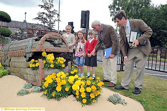 Judges Roger Burnett (right) and Jim Buttress at the underwater themed legacy bed at Broadway junction on Rochdale Road. Children from St Anne's School in Royton helped plant some of the flowers. From the left: Teigan Wheeler, Heidi Burton and Ashleigh Bowskill.