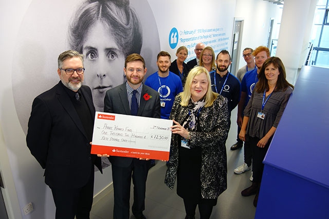 Oldham College students and staff hand over a £1,250 cheque to MP Jim McMahon