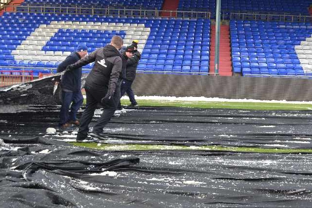 Staff and supporters help clear the snow at Boundary Park