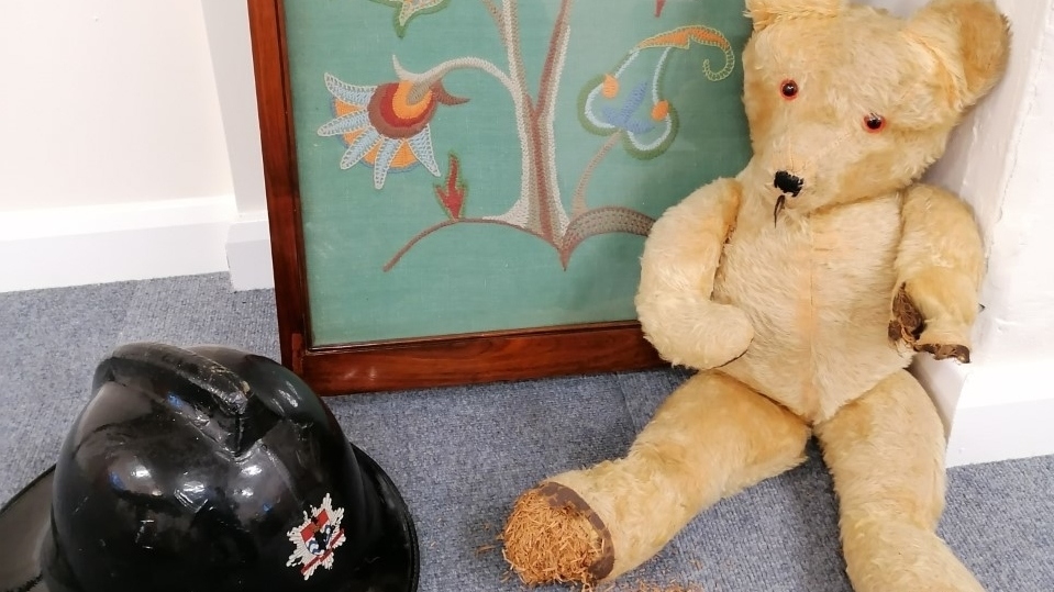 Some of the items donated, including a 1950s teddy, an original London fire brigade helmet and an embroidered picture