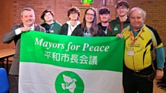 Pictured are (left to right): Richard Outram, Declan Hampson, Josh Bruton, Libby Reynolds, Adam Rennie, Billy Henshaw and Tore Naerland at the end of the event with the Mayors for Peace flag