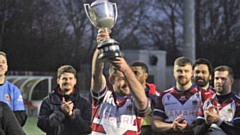 Captain Martyn Ridyard parades the Law Cup silverware after Oldham's victory over Rochdale last weekend