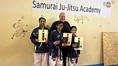 Junior black belt students Zara, Ishmaeel and Zainab are pictured with Sensei Mark Coope