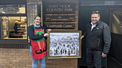 John Silcock of Silcock’s Fun Fairs presents cafe owner Amy Meadows with the framed LS Lowry print