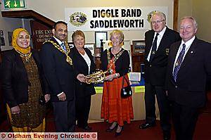 CIVIC dignitaries inspect the Diggle Band stall at the exhibition. Pictured, from left, are: Shafeena Kausar, Mayoress, the Mayor, Councillor Shoab Akhtar, Dorothy Rhodes, band treasurer, Councillor Pat Lord, chairman of Saddleworth Parish Council, Alan Rhodes, band president and Councillor Brian Lord, leader of the parish council’s Lib-Dems 