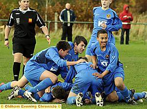 GET ME OUT OF HERE: Sam Rathbone lies at the bottom of a pile of bodies after scoring a last-gasp winner for Oldham Schools under-14s against Tameside. 