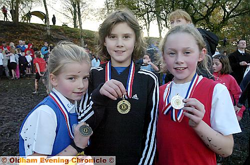 ONE-TWO-THREE: Year Three/Four girls’ race winner Sophie Hall (Mills Hill) is flanked by Hulme Estcourt’s Ellie Clinch (left), who was third, and runner-up Nancy Holden, of Diggle Primary School. 