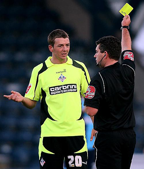 IN THE BOOK: Dale Stephens is cautioned by referee Danny McDermid. The midfielder was one of five Athletic players to be booked at Adams Park. 