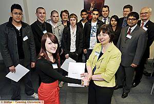 DEBBIE BRIDGE, head of centre at University Campus Oldham, presents an award to Sarah Roberts, watched by other award winners and members of the Oldham Education Trust 