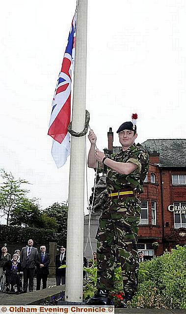 Fusilier Alex Ross raises the flag at Oldham war memorial 