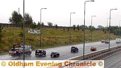 Morning commuters drive past the Hollinwood sign on the M60