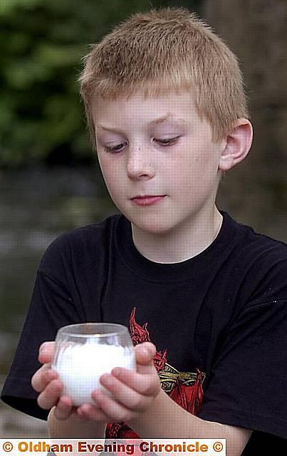 Joe Ellison (8) lights a memorial candle 
