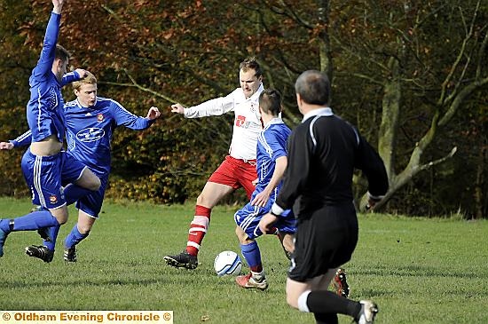 CLOSING IN: Diggle players surround Uppermill’s Andrew Pheby. 