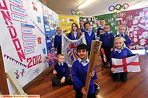 OLYMPIC art . . .Muzefa Fareed holds the torch and shows off posters made by pupils at Holy Rosary RC Primary. 