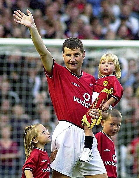 SIGNING OFF: Denis Irwin, pictured with his children, waves to the crowd at his testimonial against a Manchester City X1 side in 2000 
