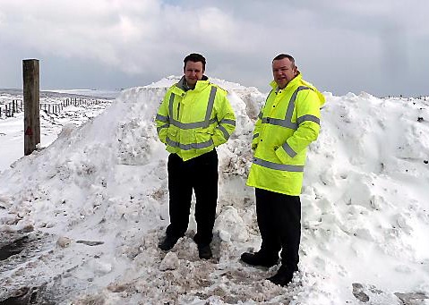 Oldham's head of highways Craig Dale (right) pictured with colleague Stephen Aikman at the man-made snow wall on the A635 Greenfield-Holmfirth road. 
