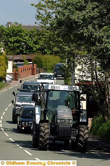 PROCESSION . . . a tractor leads the cortege of Land Rovers 
