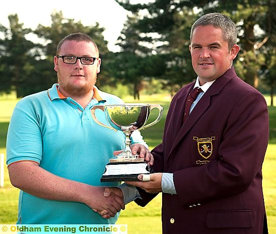 WELL DONE, CLUBMATE: Adam Rowbotham receives the District Championship trophy from Werneth captain James Buckley (right). 
