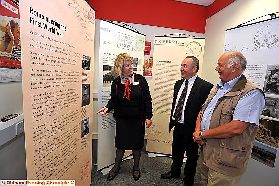 Post Office touring First World War display in Oldham Post Office. David Jones and Gillian Lee (Post Office staff) and member of public Alan Hall.