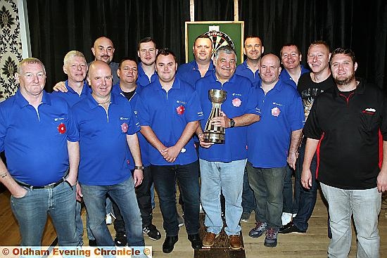 Oldham darts team and officials before their 7-3 win over Wigan at the Blue Club in Chadderton. Team manager Graham Anderson is holding the British Champions’ Cup, which Oldham lifted after victory over Yorkshire in August. 
