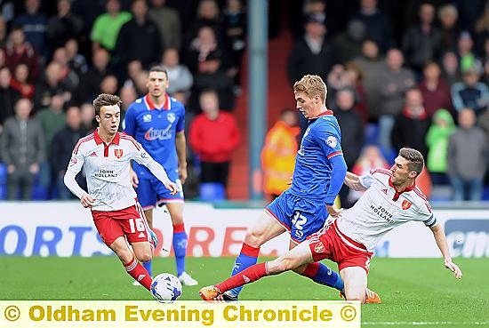 MIDFIELD DYNAMO . . . Jay Fulton attempts to get Athletic going, but is confronted by two Sheffield United tacklers.
