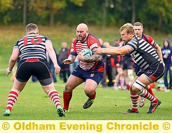 Oldham’s Joe Hesse is about to feel the force of two Bolton tacklers as he tries to drive his side forward. 