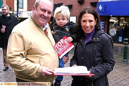 SIGNING the petition . . . Ken Rustidge with his son, Alexander, aged three, and Mrs Abrahams