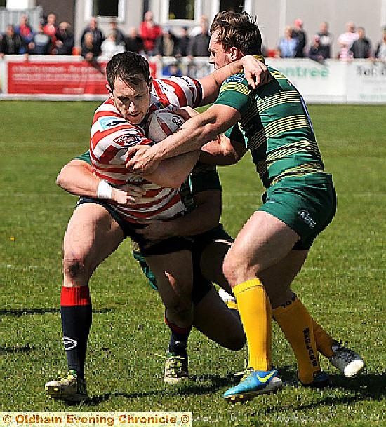 TUSSLE: Oldham’s Adam Neal tries to break through a Skolars tackle.