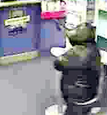 A CCTV image released by police today of one of the raiders robbing another Greater Manchester business