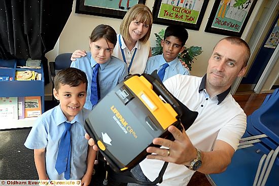 LIFESAVING kit: Paul Moss (right) with the defibrillator and (from left) Ethan Moss, Elysia Kay-Davies, headteacher Barbara Morris and Hamza Ishtiaq.