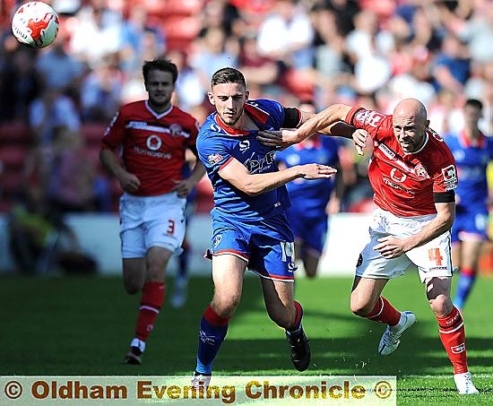 Athletic forward Jake Cassidy (above, left), uses his physical presence to hold off a Walsall opponent.