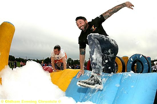 Dan Cooke, from Failsworth Fitness, in Oldham, scales the hurdle during the It’s a Knockout competition in Alexandra Park