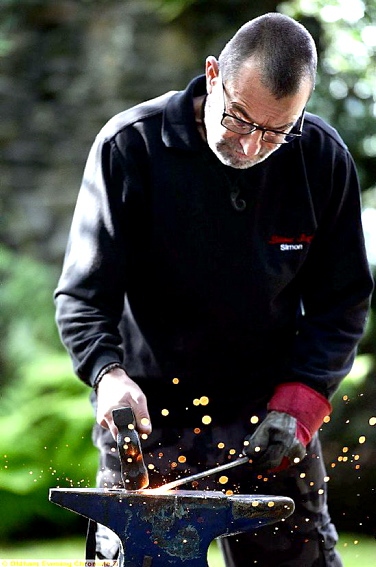 MASTER at work: blacksmith Simon Reed at work outside the Authentic gift shop, in Uppermill Picture by TIM BRADLEY