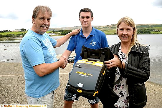 SHAKE my hand . . . Robert Dunn and daughter Emma thank Joe Ready, with the defibrillator
