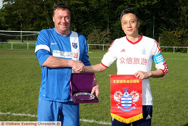 PUT IT THERE: captains Simon Tait (left) and Jain Cao exchange pennants