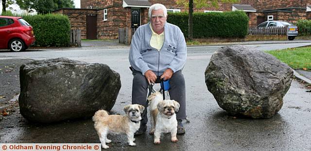 Local resident, Kevin Geany, claims Oldham council has blocked access to the car park at the back of Hollinwood cemetery  due to problems with fly tipping, which means no one can access the car park. Pic shows, Kevin with his two Shihtzu dogs, Jasper, (left) and Jamie, (right).
