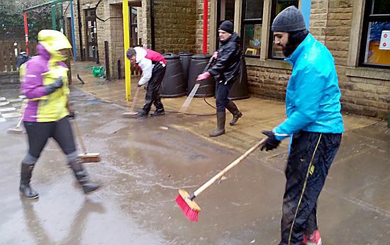 Volunteers from Oldham help clear out some of the homes badly hit by the floods