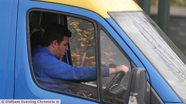 EYES off the road . . . this driver can't tear himself away from his phone on Oldham Way