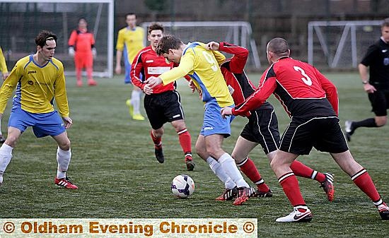 MAKING HIS PRESENCE FELT: Royton’s Alan Beckett (centre) is in the thick of the action against Hindsford.