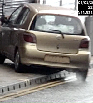 A Toyota parked diagonally over double-yellow lines and onto the pavement..