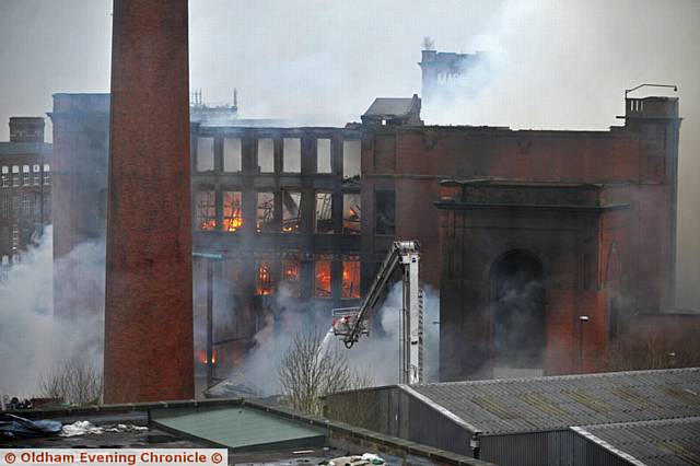 DAMPING down . . . the fire at Maple Mill, Hathershaw 