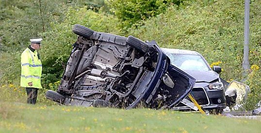 The car after it flipped and landed on top of another car
