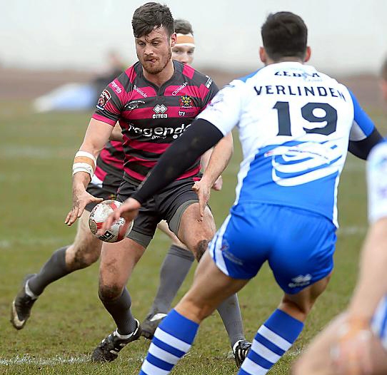 SETTING IT UP . . . Oldham’s Lewis Palfrey gets ready to take the ball at Derwent Park.