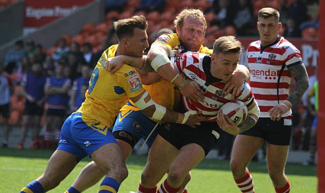 GARY Middlehurst does his best to hold off the attention of two tacklers   