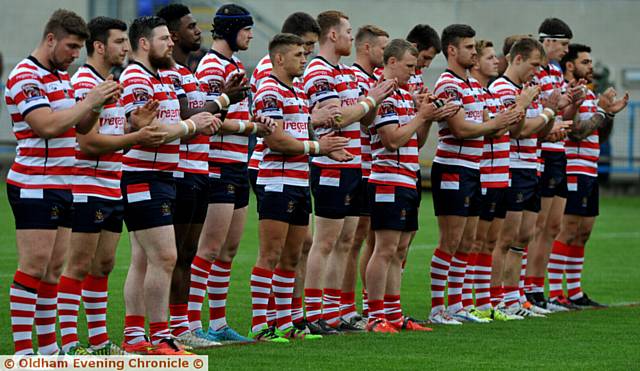 UTMOST RESPECT . . . Oldham players join in a minute's applause for Huddersfield youngster Ronan Costello.