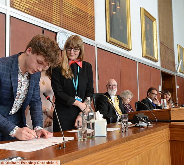 SIGNING on the dotted line . . . T Jay is watched by Oldham Council's chief executive Carolyn Wilkins