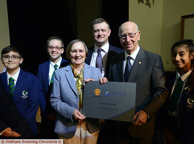 PLAQUE . . . Sir Bobby Charlton with the new plaque at Waterhead Academy. From left, Akeil Ali, Erin Baynes, Lady Norma, principal James Haseldine and Hamra Hanif-Ali
