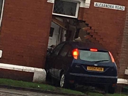 CRASH . . . A Ford Focus embedded in the side of a house. 
