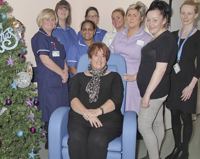 DONATION . . . Bev Woodhouse (seated) and Lauren Woodhouse (second right) hand over the chair to staff on Ward G2 at the Royal Oldham Hospital