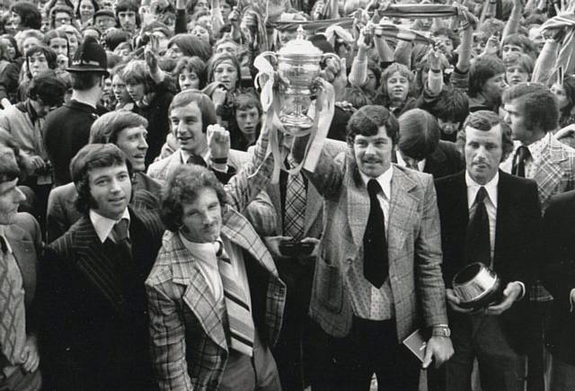 CHAMPIONS . . . a proud moment for Dick Mulvaney, centre right, as he holds the title trophy